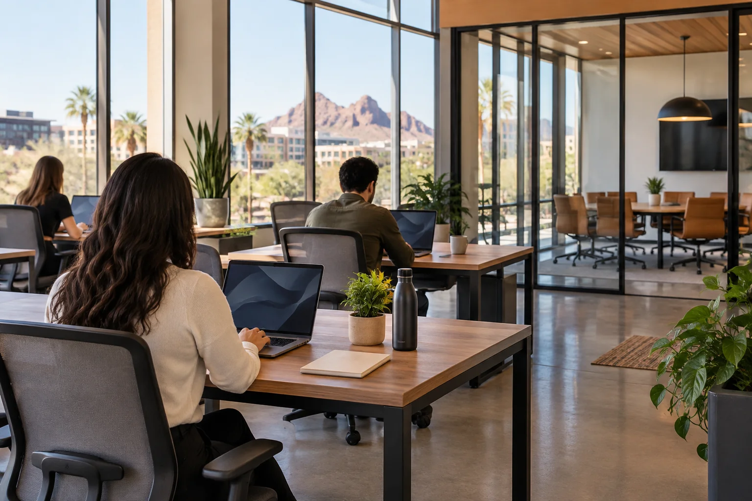 Interior of a coworking space in Tempe Arizona with shared desks and glass walled meeting room