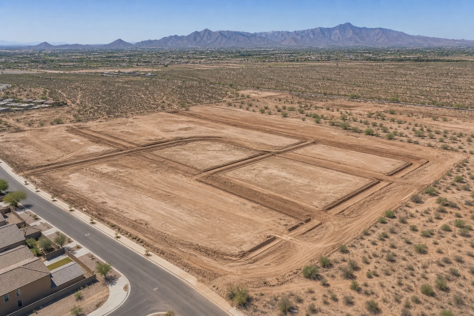 Aerial view of a raw land parcel in Queen Creek Arizona with roads and utility infrastructure under development