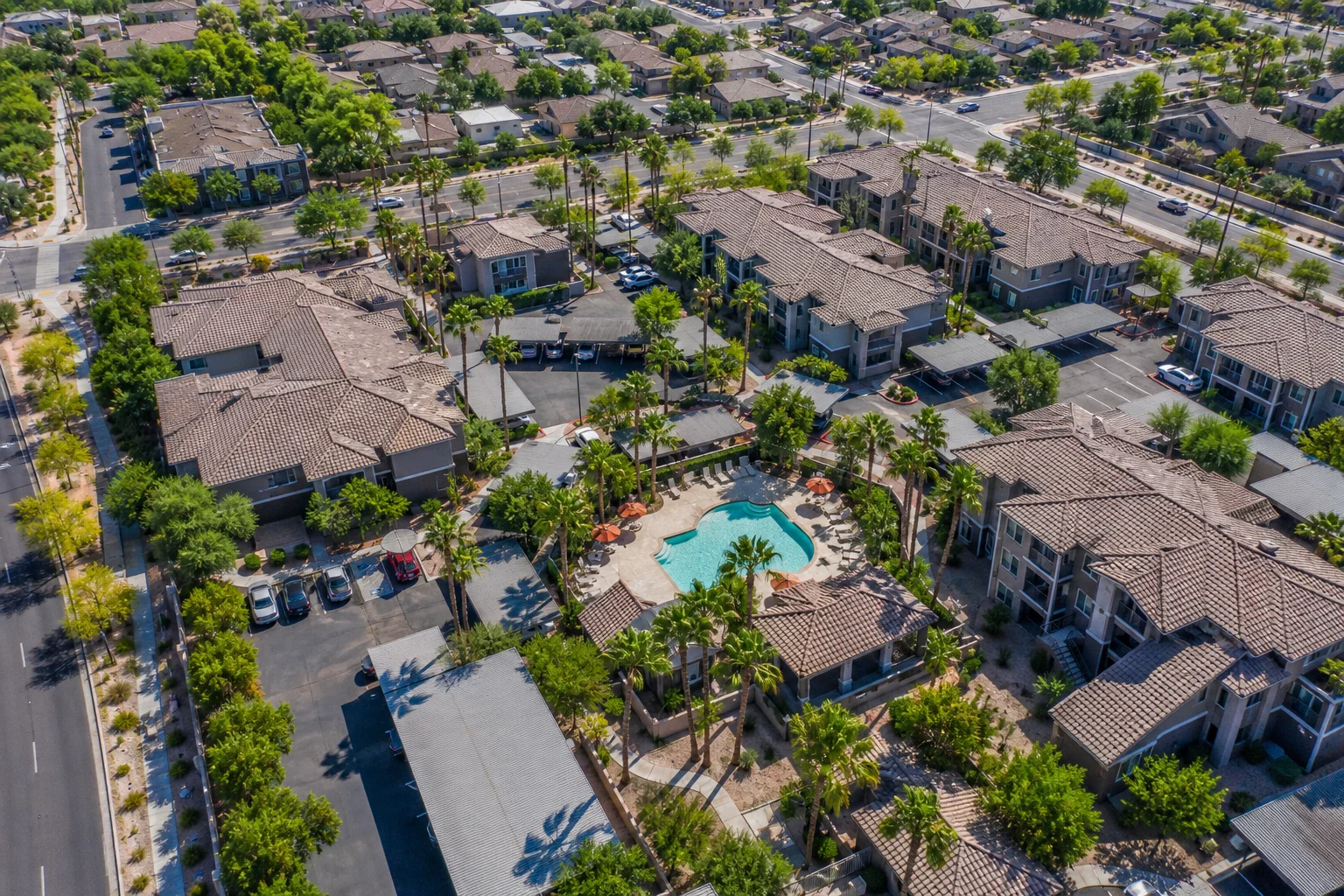Aerial photograph of a Phoenix metro suburban multifamily apartment community with pool amenity and surrounding East Valley residential landscape