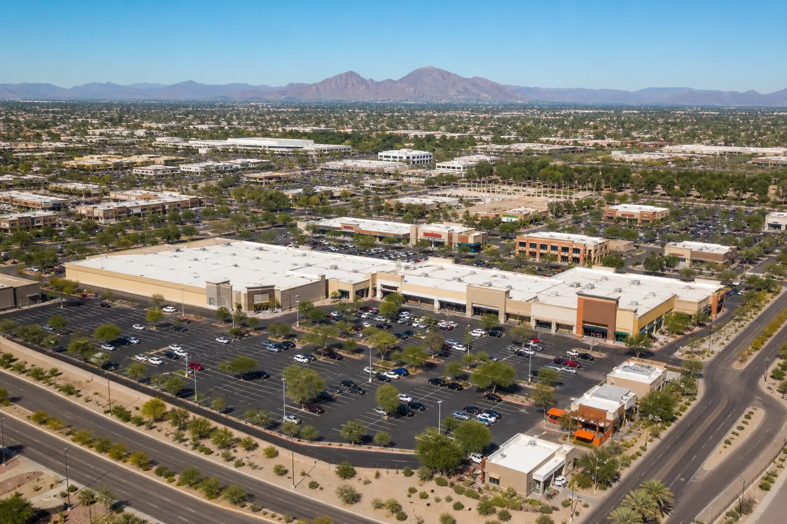 Aerial view of a Phoenix metro retail strip center with tenants and parking lot, illustrating commercial real estate investment activity in Arizona
