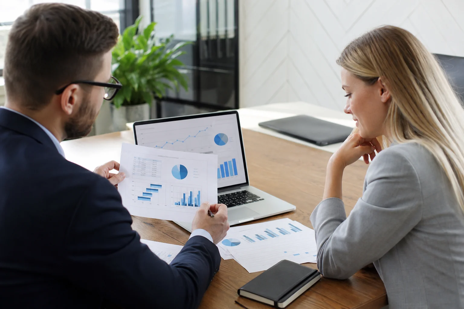 SEO agency team reviewing monthly keyword rankings and organic traffic data on multiple screens